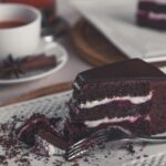 Para Bolo de Cerveja Preta (Estilo Guinness Cake), prepare uma massa úmida com cerveja stout, cacau em pó e especiarias, cobe