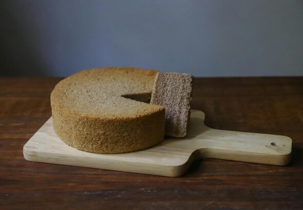 Para fazer um Bolo de Leite Quente com massa branca simples, combine farinha, açúcar, ovos, manteiga e leite quente. O leite