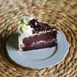 Para o Bolo Floresta Negra Tradicional, a base é um bolo de chocolate úmido, embebido em Kirschwasser, intercalado com camada