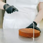 Para nivelar e cortar o bolo para rechear, utilize uma faca de serra longa ou nivelador de bolos, garantindo uma superfície p